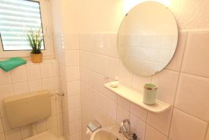 a bathroom with a mirror and a sink and a toilet at Ferienhaus Gruber in Norddeich