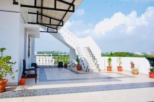 a balcony of a house with stairs and plants at Janz Marina Bay in Puducherry