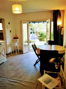 a living room with a table and a door to a patio at Studio jardin privatif 300m de la plage in Sainte-Maxime