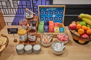 a table topped with bowls of food and bowls of fruit at Appart Hotel Odalys City Paris Levallois in Levallois-Perret +53 photos