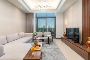 a living room with a couch and a tv at Samaya Holiday Homes - Family Luxury Suites in Dubai