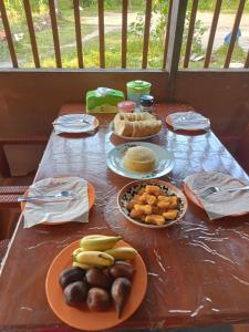 a wooden table with plates of food on it at Moana Raja Ampat Homestay in Poelau Mansoear +63 photos