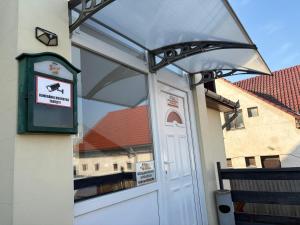 a glass door to a building with a sign on it at Sárga Csikó vendégház in Debrecen