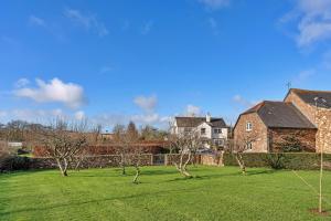 a yard with trees in front of a house at Finest Retreats - Stable Cottage at Yealmpton in Yealmpton