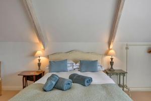 a bedroom with a bed with two blue pillows at Finest Retreats - Stable Cottage at Yealmpton in Yealmpton