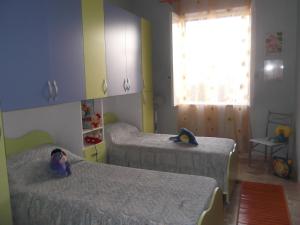 Un dormitorio con dos camas y una ventana. en Siculiana Marina - oasi wwf, en Siculiana Marina
