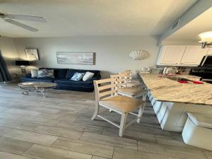 a kitchen and living room with a blue couch at Vacation in Comfort and luxury - 1 BR Direct Oceanfront - Wyndham Ocean Walk Resort 1607 in Daytona Beach +45 photos
