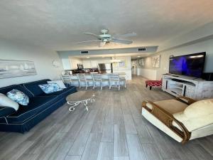 a living room with a blue couch and a tv at Vacation in Comfort and luxury - 1 BR Direct Oceanfront - Wyndham Ocean Walk Resort 1607 in Daytona Beach