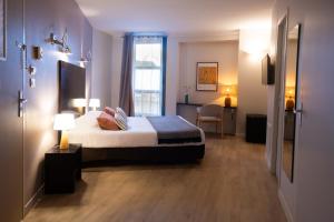 a hotel room with a bed and a window at Hôtel les jardins du canal - piscine chauffée - solaire eco responsable - parking - garage - bornes électriques - accueil vélos - kids friendly in Aigues-Mortes +36 photos