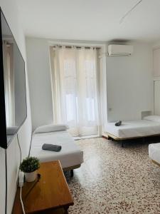 a living room with two beds and a tv at Hostal Ruano in Madrid
