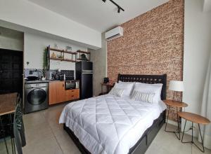 ein Schlafzimmer mit einem großen Bett und einer Backsteinwand in der Unterkunft Stúdio do Nicolas in Niterói + 19 Fotos