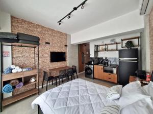 ein Schlafzimmer mit einem großen Bett und eine Küche in der Unterkunft Stúdio do Nicolas in Niterói