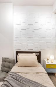 イロイロにあるPerfect for Staycation 2BR Loftのベッドと椅子のある白い寝室