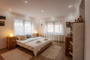 Un dormitorio con una cama grande y dos ventanas. en Vik's Home, en Sighişoara