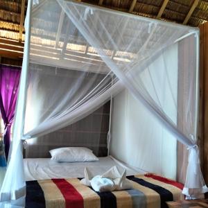 a bedroom with a bed with a canopy at Moana Raja Ampat Homestay in Poelau Mansoear +58 photos
