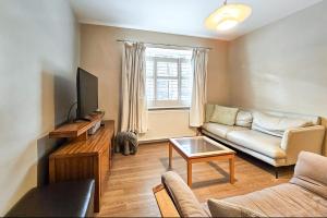 a living room with a couch and a tv at Valley Mount House & Apartment in Harrogate