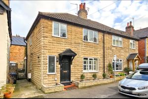 a brown brick house with a black door at Valley Mount House & Apartment in Harrogate