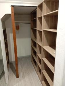 a closet with wooden shelves in a room at Grand Studio chambre séparée in Arpajon-sur-Cère
