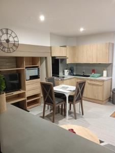 a kitchen with a table and chairs in a kitchen at Grand Studio chambre séparée in Arpajon-sur-Cère