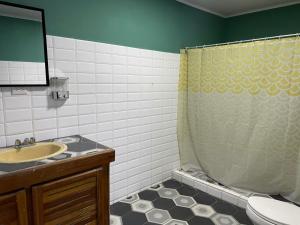 a bathroom with a sink and a shower curtain at la casona rio in Alajuela