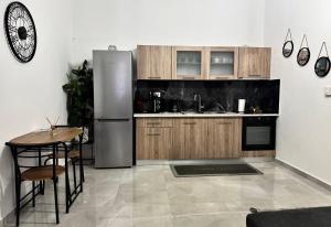 a kitchen with a stainless steel refrigerator and a table at Το Φαράγγι του Παρνασσού 3 in Velítsa