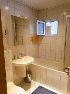 un bagno con lavandino, vasca e WC di Sonnenschein1R mit Terrasse und Garten a Friedrichshafen
