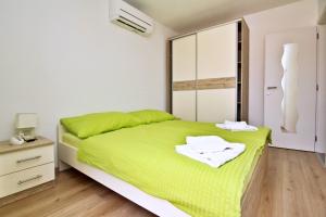 a bedroom with a green bed and a dresser at Apartment Ivo P. in Šilo