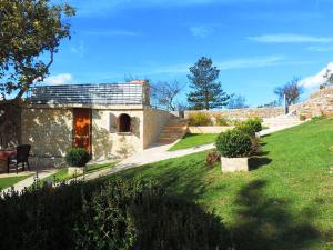 a stone house in a field with a grass yard at Holiday Home Voloder in Tarabnik