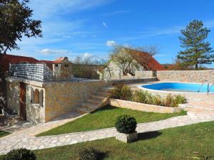 a backyard with a stone wall and a swimming pool at Holiday Home Voloder in Tarabnik