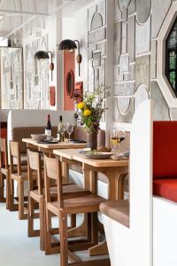a dining room with a wooden table and chairs at Grand Pigalle Experimental in Paris +40 photos