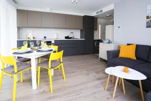 a kitchen and a living room with a table and chairs at Pelso Beach Balatonlelle, Seaside Apartman in Balatonlelle +20 photos