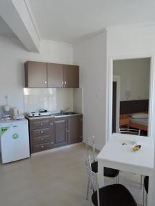 uma cozinha com uma mesa branca e um frigorífico branco em Fantasia Hotel Apartments em Cós