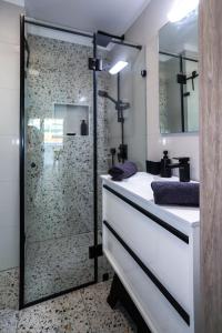 a bathroom with a glass shower and a white sink at Pelso Beach Balatonlelle, Seaside Apartman in Balatonlelle