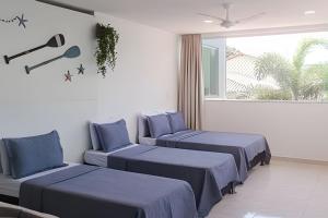 a room with three beds with blue sheets and a window at Casa c/ Piscina e Quintal • Até 15 Pessoas • NOMDS in Vila Velha +127 photos