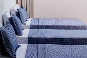 two beds with blue and white sheets and pillows at Casa c/ Piscina e Quintal • Até 15 Pessoas • NOMDS in Vila Velha