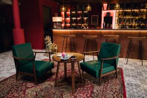 a bar with green chairs and a table and a counter at Ḥokma Boutique Hotel & Tropical Lounge in Phi Phi Islands +79 photos