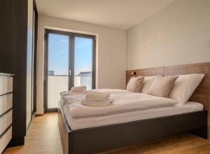 a large bed in a room with a large window at Sunset Apartments in Kovářov