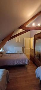 a attic bedroom with a bed and a mirror at Spacious house in Montignies-sur-Roc with garden in Montignies-sur-Roc