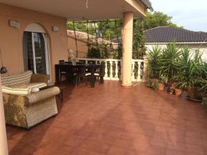 a patio with a table and chairs on a balcony at Valencia, villa, piscina privada, junto A-7 cerca de playas, aeropuerto, Cheste in Torrent
