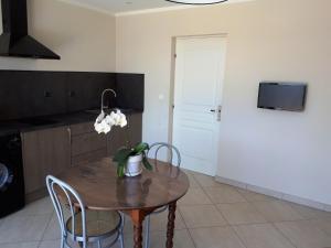 a kitchen with a table with a vase of flowers on it at Résidence BELLA VISTA in Santa-Maria-di-Lota