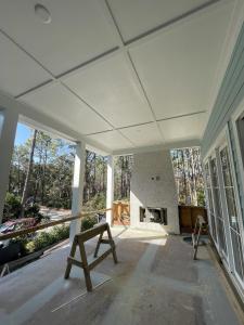 a large screened porch with a fireplace on a house at 2 Abalone Ln, New Construction, Luxury Finishes, Pool, Game Room in Hilton Head Island