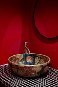 a sink in a bathroom with a red wall at Ḥokma Boutique Hotel & Tropical Lounge in Phi Phi Islands