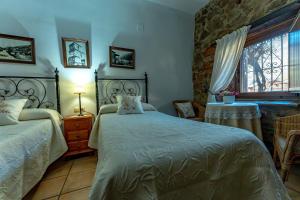 a bedroom with two beds and a window at El Cerrillo in Navaconcejo +42 photos