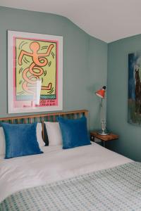 HawardenThe Pedlars Flat的一间卧室配有一张带蓝色枕头的床和一幅画