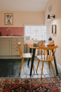 a kitchen with a table and two chairs in a room at The Pedlars Flat in Hawarden +16 photos