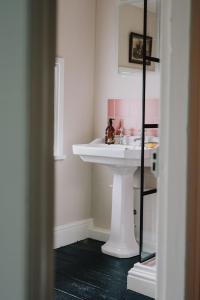 a bathroom with a white sink and a mirror at The Pedlars Flat in Hawarden