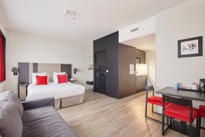 a hotel room with a bed and a table at Appart'hôtel Odalys City - Paris XVII in Paris
