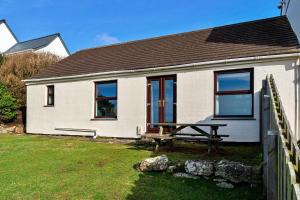 a house with a picnic table in front of it at Finest Retreats - Wolf Rock in Sennen