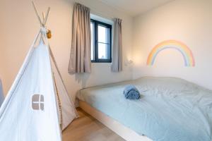 a bedroom with a bed with a rainbow on the wall at Nature'Hayette in Tenneville