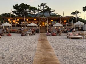 a wooden walkway on the beach with a restaurant at T2 neuf bord de plage - terrasse - CALVI in Calvi